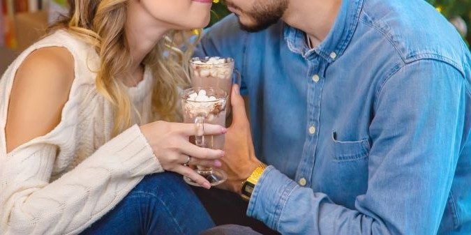 Lovers with cocoa and marshmallows on a christmas scene