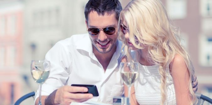 couple looking at smartphone in cafe in the city
